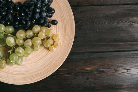 grapes on a plate wooden background fruit freshnessの写真素材