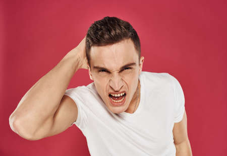 emotional man angry facial expression white t-shirt red background