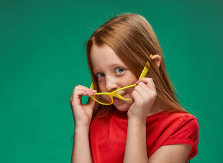 cute red-haired girl yellow glasses facial emotions schoolの写真素材
