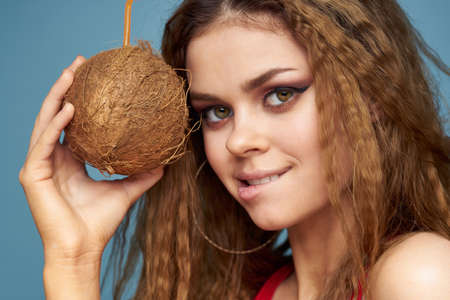 woman with coconut cocktail in hands wavy hair bright makeup lifestyle studio summer vacationの写真素材