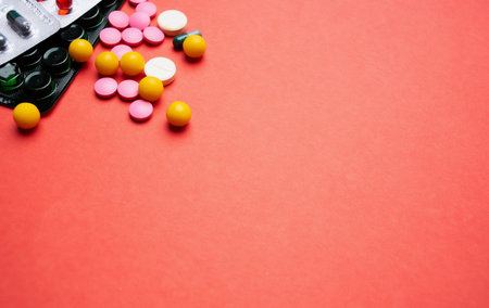multicolored pills on red background medicine healthの写真素材