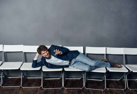 A man lies on chairs waiting for job interview manager