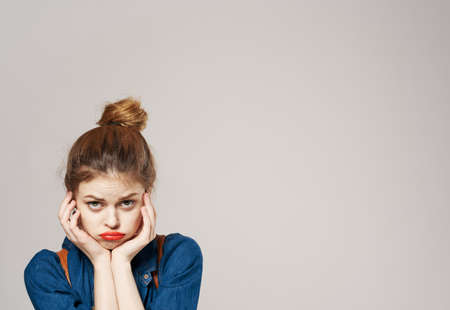 cheerful woman in fashionable clothes backpack studio gray backgroundの写真素材