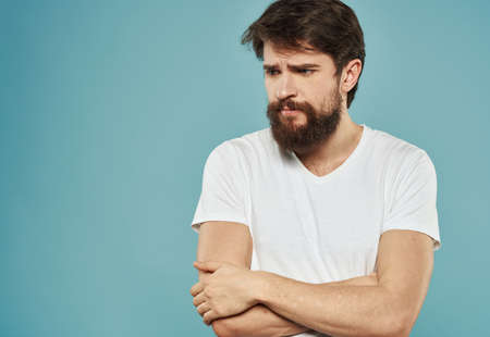 Upset man on a blue background crossed his arms on his chest emotions model sadnessの写真素材