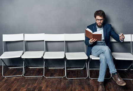 Man sitting on a chair waiting for job interview work lifestyle emotionsの写真素材