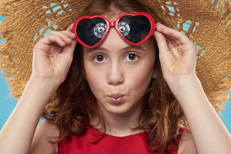 Girl in a beach Straw hat in sunglasses curly hair fun blue background