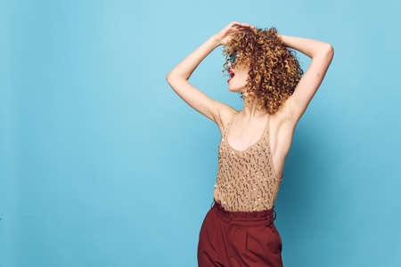 Woman portrait Curly hair hands on head elegant style red pantsの写真素材
