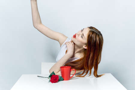 Woman in white dress sitting at the table take a selfie with phone rose flowerの写真素材