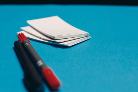 blank business cards on office desk blue background pens mocap