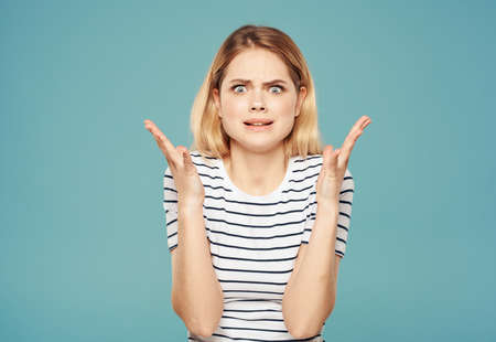 Upset woman on a blue background gestures with her hands Copy Space Modelの写真素材