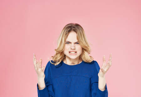 Cute blonde blue dress lifestyle emotions displeasure pink backgroundの写真素材