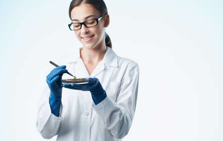 woman with plant in soil research laboratory gloves doctorの写真素材