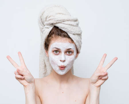 cheerful woman with bare shoulders gesturing with hands cream face mask emotionsの写真素材