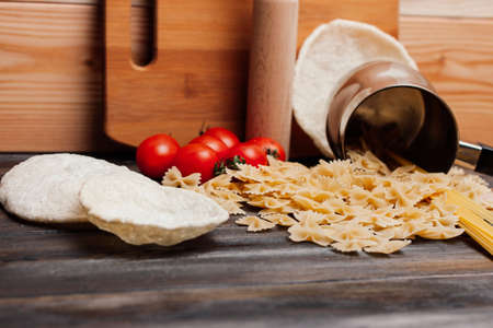 pasta on a wooden table cherry tomatoes kitchenware cookingの写真素材