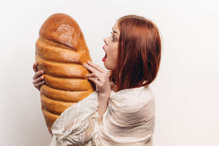 loaf of bread flour products loaf young woman on a light background emotionsの写真素材