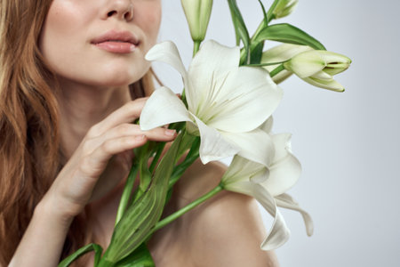 Portrait of a beautiful woman with white flowers on a light backgroundの写真素材
