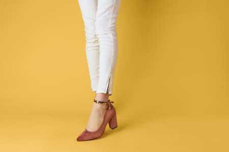 Female feet fashionable shoes luxury yellow background elegant styleの写真素材