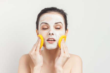 brunette with bare shoulders facial masking skincareの写真素材