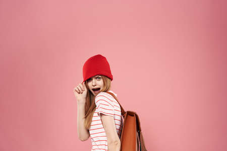 Cheerful fashionable woman in hat studio pink backgroundの写真素材