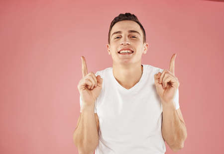 happy guy gesturing with his hands and showing fingers to the side emotions modelの写真素材