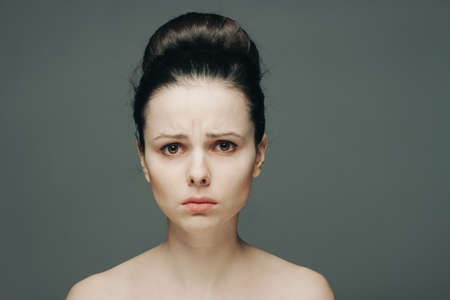 woman with bare shoulders clear skin collected hair emotionsの写真素材