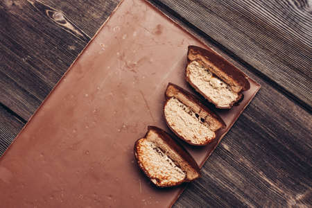 halved brownie and chocolate bar on wooden table