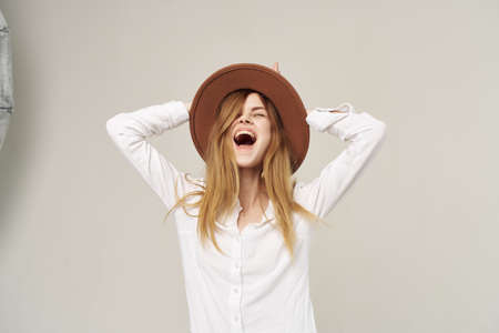 emotional woman wearing hat white shirt fashion studio cropped viewの写真素材