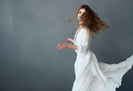 Woman in white dress glamor dance gray backgroundの写真素材