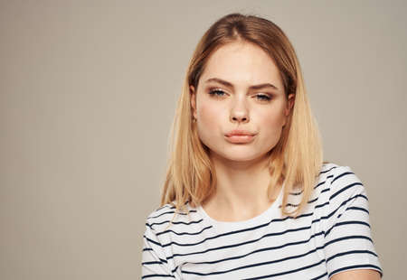 indignant blonde on beige background in striped t-shirt model cropped viewの写真素材