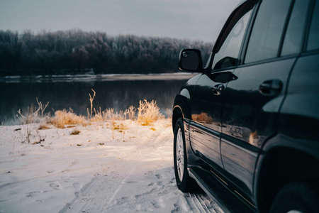 black car nature river winter trip travel landscapeの写真素材