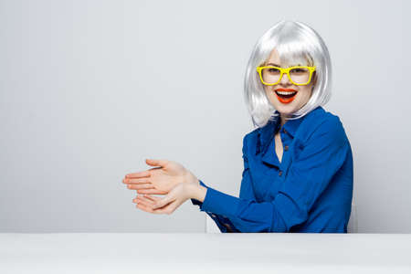 cheerful woman with red lips in a white wig gesturing with her hands yellow glasses