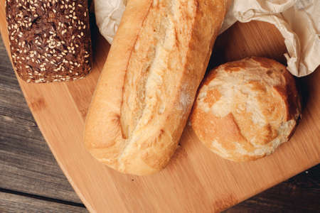 flour products loaf of bread and wood board light background