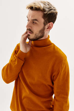 man in a sweater looking to the side fashionable hairstyle mens clothing