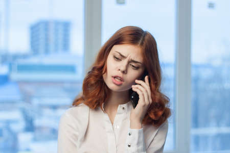 red-haired woman talking on the phone in the office businesswoman job managerの写真素材