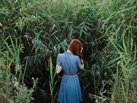 Woman outdoors near green grass and a river in the background
