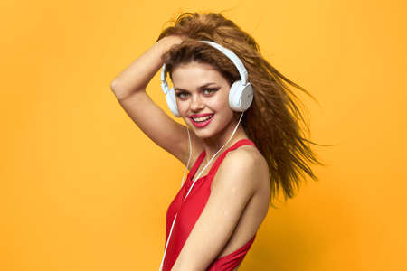 woman in headphones listening to music red t shirt emotions fashion yellow background lifestyle