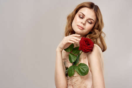 Beautiful woman in rose dress holding a holiday gift charmの写真素材
