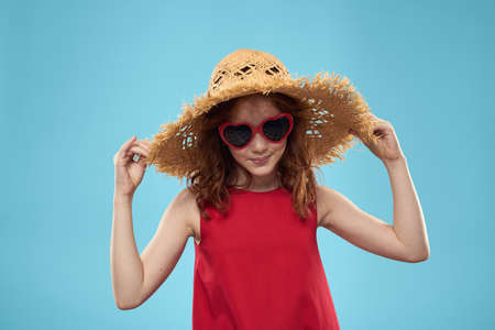 Girl in a beach Straw hat in sunglasses curly hair fun blue background