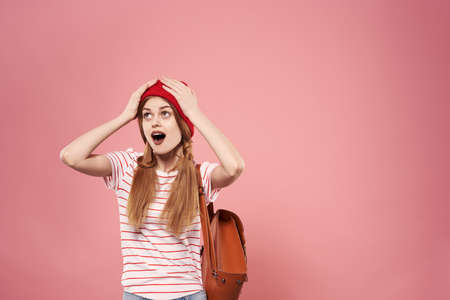 Fashionable glamorous woman in red hat backpack student hipster pink backgroundの写真素材
