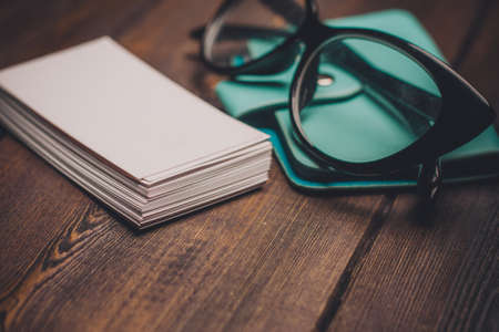glasses business cards wallet wooden background and textureの写真素材