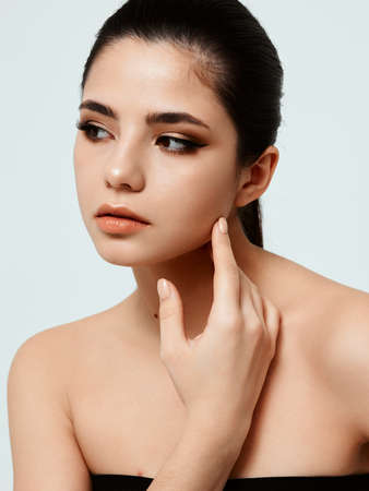 Woman in black dress nude adhesive makeup model hand near faceの写真素材