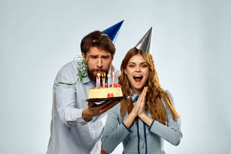 Emotional man with cake and pretty woman party disco blue background