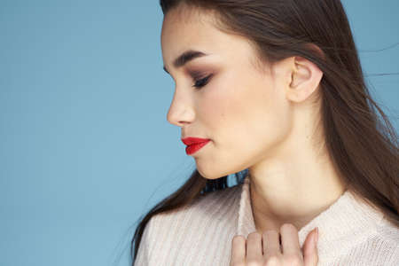 Pretty woman red lips white jacket attractive look close-up blue background