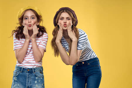 funny mom and daughter fashion clothes studio lifestyle yellow backgroundの写真素材