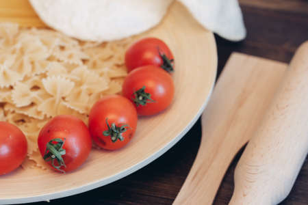 italian pasta on a wooden table cherry tomatoes cookingの写真素材