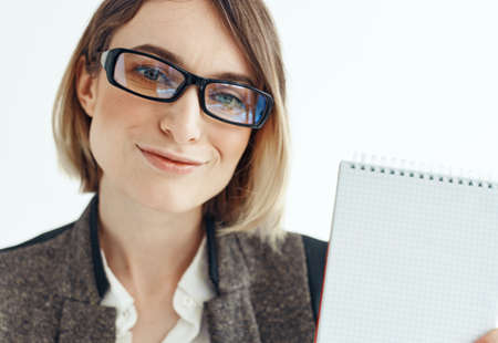 Portrait of a business woman in a suit with documents in hands on a light backgroundの写真素材