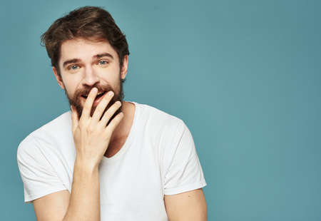 Emotional man on a blue background gestures with his hands surprise model delightの写真素材