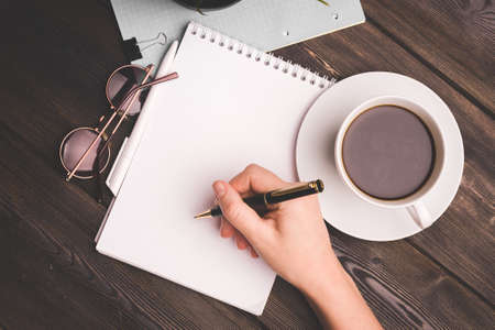 notepads ballpoint pen on table coffee cup potted flower office work freelancer