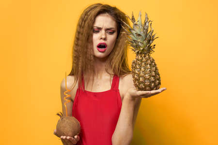 woman with pineapple and coconut cocktail exotic fruits summer lifestyle yellow backgroundの写真素材