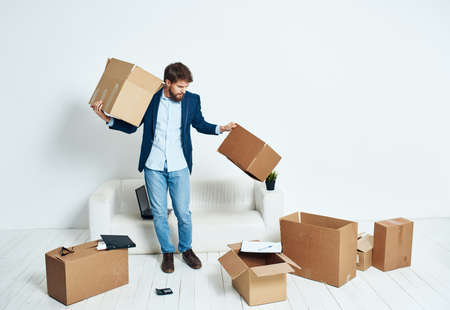 Business man in a suit boxes in hands picking things movingの写真素材